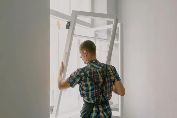 Fitter installing a white uPVC window frame